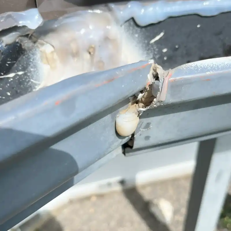 A close up of the side of a car with some rust