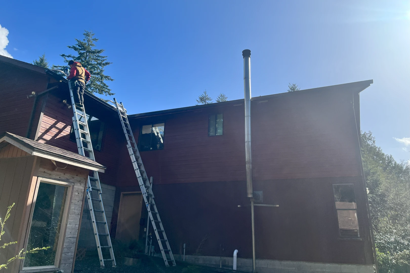 A man on a ladder working on the side of a building.